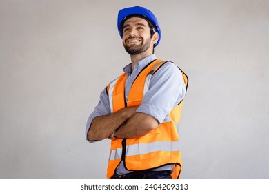Portrait of handsome successful architect standing with arms crossed in building in construction process.