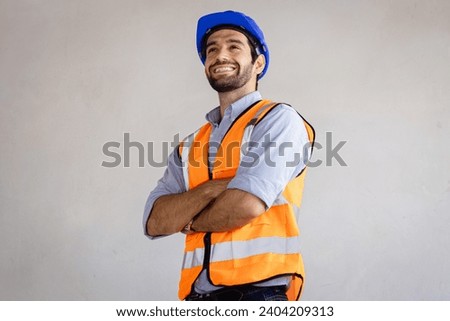 Portrait of handsome successful architect standing with arms crossed in building in construction process.