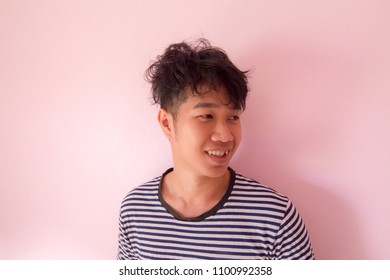 Portrait Of A Handsome Thailand Man Asia.Image Of Young Confused Asian Man Standing Over Pink Wall. Do Not Look At The Camera Accidentally.