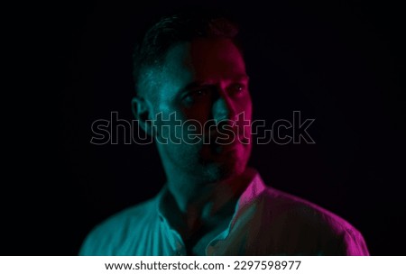 Portrait of a handsome unshaven middle-aged man. In neon light.
