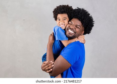 Portrait of handsome young african american father and his handsome son hugging, looking at camera and smiling.  - Powered by Shutterstock