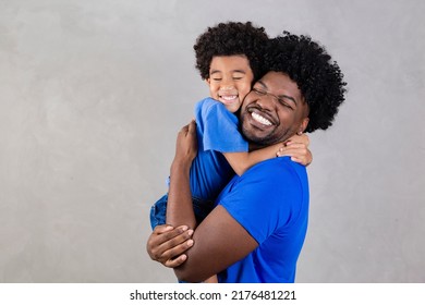 Portrait of handsome young african american father and his handsome son hugging, looking at camera and smiling.  - Shutterstock ID 2176481221