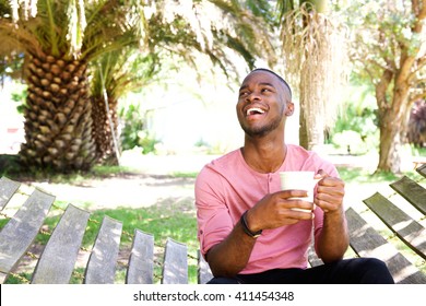 Portrait of handsome young african man relaxing outdoors with a cup of coffee 
