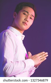 Portrait Of A Handsome Young Asian Business Male Expert In White Shirt Looking At Camera With Confident Expression, Isolated Over Violet Or Puple Background. Human Faces And Images