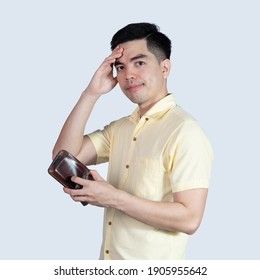 Portrait Handsome Young Asian Man Wearing A Yellow Shirt Stressed Because Empty Wallet No Money Isolated On White Background. Businessman Concept. Asia People.