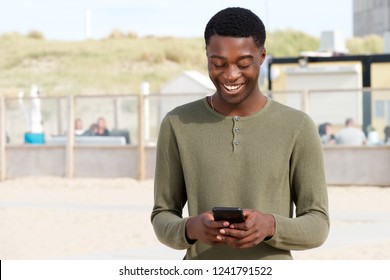 Portrait Of Handsome Young Black Man Looking At Mobile Phone 