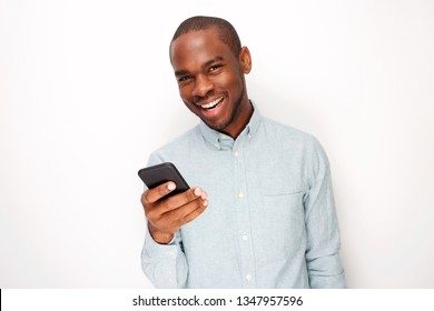 Portrait Of Handsome Young Black Man Holding Mobile Phone Against White Background