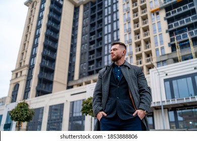 Portrait of a handsome young businessman standing outside a modern building. View from below.