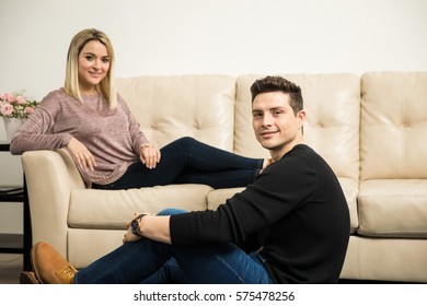 Portrait of a handsome young Hispanic man relaxing at home with his girlfriend