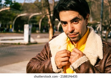 A portrait of a handsome young latino man walking alone down a street on a sunny day