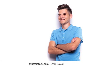 Portrait Of Handsome Young Man In Blue Polo Shirt Posing Hands Crossed While Looking Away From The Camera In White Isolated Studio Background