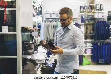 Portrait Of Handsome Young Man Buying Shoes In The Store.