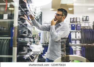 Portrait Of Handsome Young Man Buying Shoes In The Store.