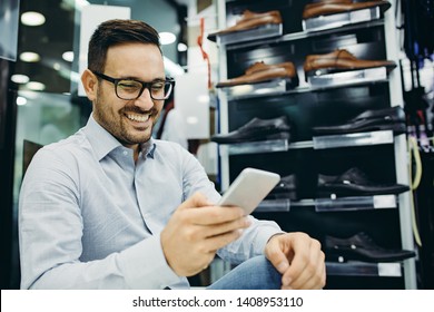 Portrait Of Handsome Young Man Buying Shoes In The Store.