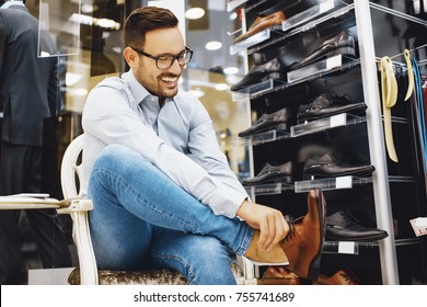 Portrait Of Handsome Young Man Buying Shoes In The Store.