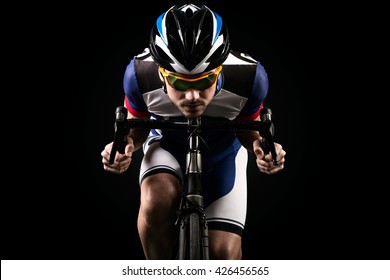 Portrait Of Handsome Young Man Cycling Indoor. Isolated On Black.