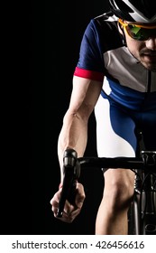 Portrait Of Handsome Young Man Cycling Indoor. Isolated On Black.