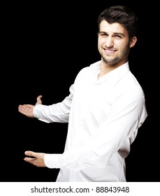 Portrait Of A Handsome Young Man Gesturing Welcome Over Black