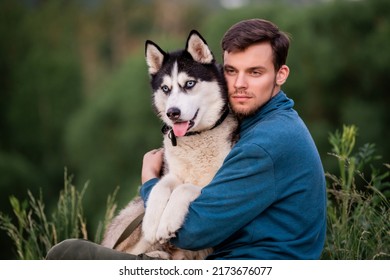 Portrait of handsome young man and his pet dog Siberian Husky in nature. - Shutterstock ID 2173676077