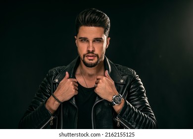 Portrait of a handsome young man with manly face. Male beauty. Fashionable brunet guy in black leather jacket looking at the camera. A lot of copy space.