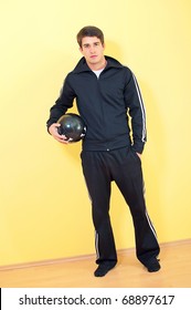 Portrait Of A Handsome Young Man In Track Suit Holding A Football On Uniform Background