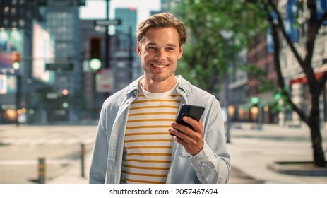 Portrait of a Handsome Young Man Wearing Casual Clothes and Using Smartphone on the Urban Street. Manager in Big City Connecting with People Online, Messaging and Browsing Internet. - Powered by Shutterstock