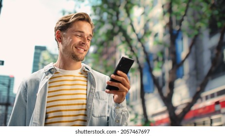 Portrait of a Handsome Young Man Wearing Casual Clothes and Using Smartphone on the Urban Street. Manager in Big City Connecting with People Online, Messaging and Browsing Internet. - Powered by Shutterstock