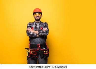 Portrait Of Handyman With Tool Belt Isolated On Yellow Background