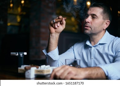 Portrait Of Hansome Man Smoking Cigar In A Lounge Bar