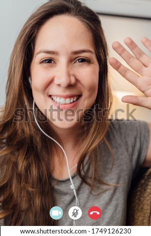 Portrait of happy 30s aged beautiful girl making video calling with smartphone at home. waving on phone screen. Using conferencing meeting online app