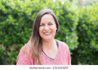 Portrait of a happy 40-45 years old woman posing in the park on a sunny day. Confidence and tranquility of a mature woman. Happiness, lifestyle. - Powered by Shutterstock