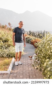 Portrait Of Happy 60-years Old Man Walking With His Dog