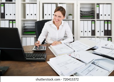 Portrait Of A Happy Accountant Woman Calculating Invoice