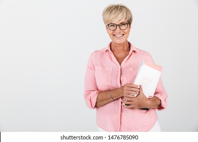 Portrait Of Happy Adult Woman Wearing Eyeglasses Holding Studying Book Isolated Over White Background In Studio