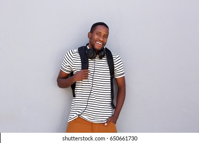 Portrait of happy african american college student with bag standing against gray background
