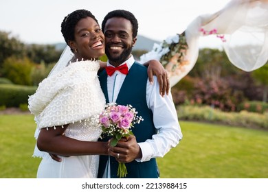 Portrait of happy african american couple holding hands during wedding. Wedding day, friendship, inclusivity and lifestyle concept. - Powered by Shutterstock