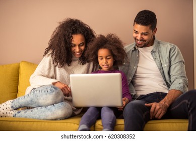 Portrait Of Happy African American Family Bonding With Computer.