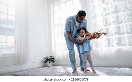 Portrait Of Happy African American Father, Teacher And Little Black Girl Daughter Playing Violins. Family Leisure Time Doing Hobby With Music Instrument. Love Together Fatherhood, Father's Day Concept