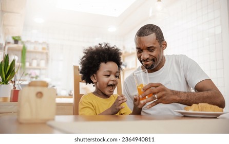 Portrait of happy African american father and son hands drink eat during breakfast time at dining table with copy space. Single dad family love lifestyle, father’s day warm gentle family. - Powered by Shutterstock