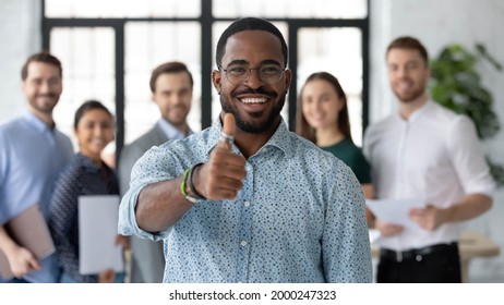 Portrait of happy African American male business leader making thumb up like gesture at camera. Employee satisfied with job and work with great team. Client giving positive feedback to company service - Powered by Shutterstock