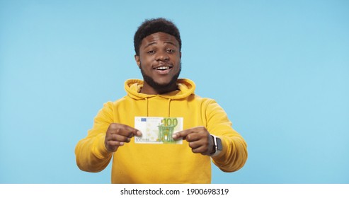 Portrait Of Happy African American Man Holding In Hands Euro Banknotes Isolated Over Blue Background. Euro Money. 