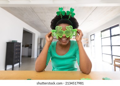 Portrait of happy african american mid adult woman wearing shamrock headband and shutter glasses. unaltered, lifestyle, st patrick's day, holiday and celebration concept. - Powered by Shutterstock