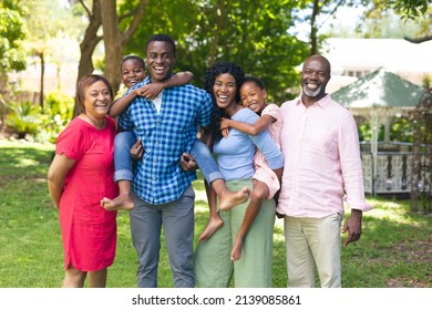 Portrait of happy african american multi-generational family standing together in backyard. unaltered, lifestyle, family, togetherness, leisure and weekend concept. - Powered by Shutterstock