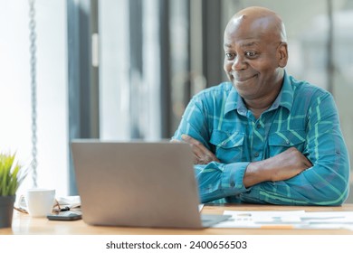 Portrait of happy African American small business owner. Millennial black smiling, sitting and using the laptop ,and holding a cup of coffee work in modern office. - Powered by Shutterstock