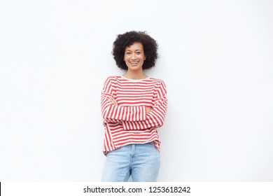 Portrait of happy african american woman smiling with arms crossed against white wall