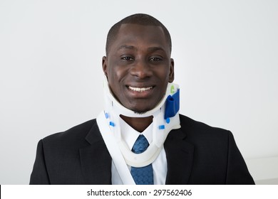 Portrait Of Happy African Businessman With Neck Brace - Powered by Shutterstock