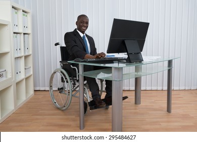 Portrait Of Happy African Businessman Working In Office Sitting On Wheelchair