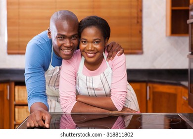 Portrait Of Happy African Couple Leaning Against The Kitchen Counter