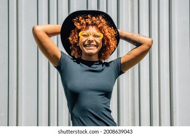 portrait of happy afro american girl smiling with glasses and hat