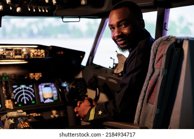 Portrait Of Happy Airliner Sitting In Airplane Cockpit Ready To Fly, Using Control Panel Navigation And Dashboard Command Buttons. Pilot Flying Aircraft With Windscreen Compass And Radar.